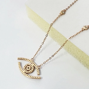 Macro shot of rose gold Evil Eye pendant with pavé details and micro-inlay texture