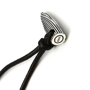 Macro shot of S925 sterling silver bullet pendant showing texture and black cord