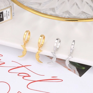 Detailed view of gold and silver baroque moon hoop earrings on a minimalist white stand