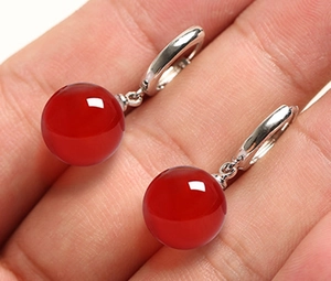 Close-up of vintage s925 silver drop earrings with polished 12mm red agate beads