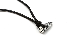 Macro shot of S925 sterling silver bullet pendant with textured metal finish and black cord
