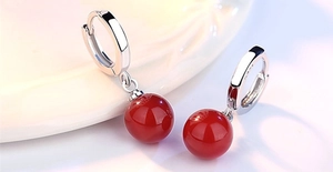 Macro view of S925 sterling silver leverback earrings with red agate beads and tassels