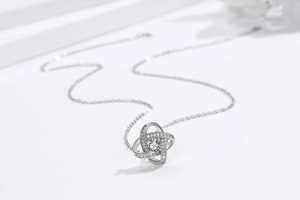 Macro detail of S925 sterling silver four-leaf clover pendant with sparkling zircon stone
