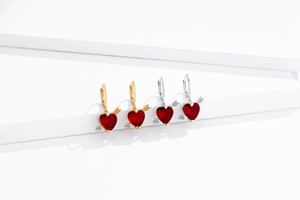 Détail de pierres rubis en forme de cœur avec flèche de Cupidon en or et argent