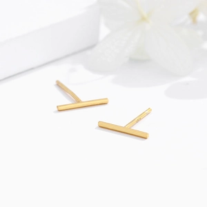 Minimalist S925 sterling silver bar stud earrings in gold finish on elegant white decor