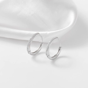 Dettaglio di orecchini a cerchio in argento sterling S925 con una fila di zirconi brillanti