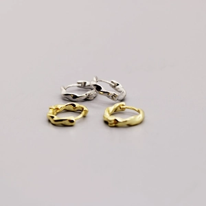Detailed view of gold and silver S925 sterling silver hoop earrings with lava wave texture