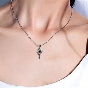 Close-up of S925 silver necklace featuring a rhombus pendant with a green gemstone on neck