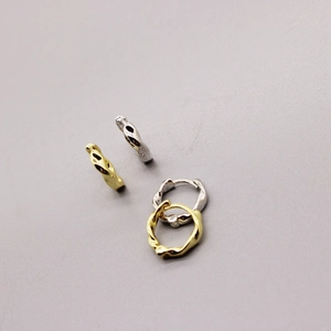 Close-up of artistic twisted geometric gold and silver plated hoop earrings set