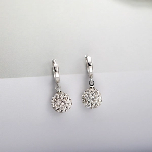 Macro detail of S925 sterling silver hoop earrings with shimmering crystal pavé ball