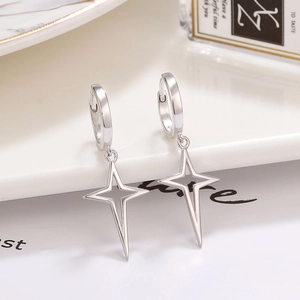 Détail de boucles d'oreilles créoles minimalistes en argent 925 avec étoiles évidées