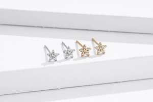 Macro shot of silver and gold star stud earrings with sparkling pavé cubic zirconia