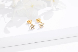 Close-up of gold S925 sterling silver star stud earrings with white zircon accents