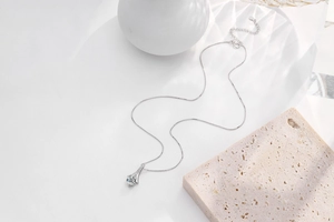 Macro shot of silver pendant necklace with sparkling round main stone and box chain