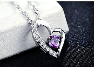 Macro detail of S925 silver heart pendant with purple gemstone and white zircon stones