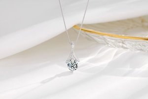 Detail of s925 silver pendant with round brilliant zircon on elegant white silk