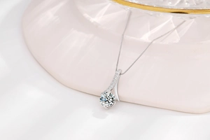 Detailed view of silver solitaire necklace with sparkling round zircon on stone prop
