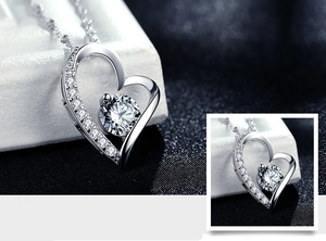 Macro shot of silver heart pendant with brilliant central stone and micro-pave white zircons
