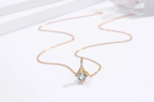 Détail du collier chevron doré orné de zircons cubiques et d'une pierre centrale brillante