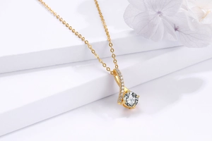 Détail macro d'un collier chevron en argent 925 avec zircon rond sur présentoir blanc