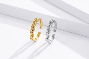 Detail of twisted 925 silver knot rings in gold and silver finish with S925 hallmark