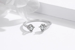 Detailed view of silver open ring featuring two round sparkling zircon stones in prong setting