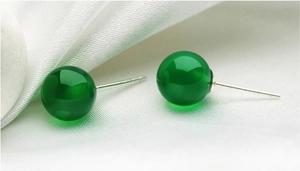 Macro shot of 925 sterling silver stud earrings with polished green chalcedony round beads