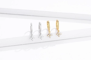 Detail of S925 sterling silver hoop earrings with four-petal zircon flower charms