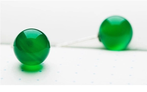 Macro detail of natural green chalcedony stud earrings with polished round bead texture