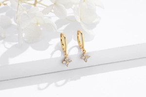 Detail of gold S925 silver hoop earrings with four-leaf zircon flower charms