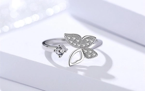 Makroaufnahme von Silber-Schmetterlingsring mit Mikropavé-Kristallen auf weißem Sockel
