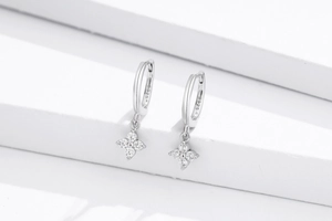 Macro shot of S925 sterling silver hoop earrings with four-leaf clover zircon pendant