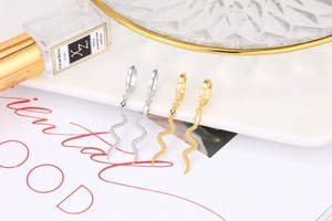 Detail of S925 sterling silver and gold-plated snake hoop earrings on a display stand
