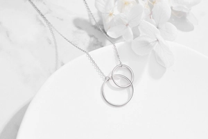 S925 sterling silver interlocking double circle necklace on a white marble display tray