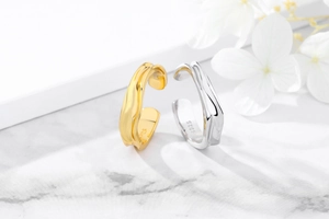 Detailed close-up of S925 hallmark on irregular gold and silver textured rings