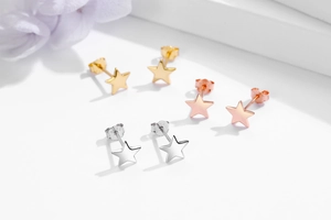 Dettaglio macro di orecchini a stella in argento 925 in oro, oro rosa e argento