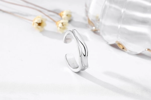 Macro detail of S925 sterling silver ring showing irregular hammered texture and hallmark