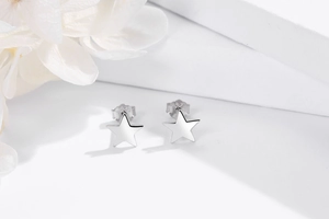 Dettaglio dei piccoli orecchini a stella in argento sterling 925 su piedistallo bianco