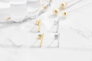 Detailed view of minimalist geometric bar stud earrings with round cubic zirconia settings