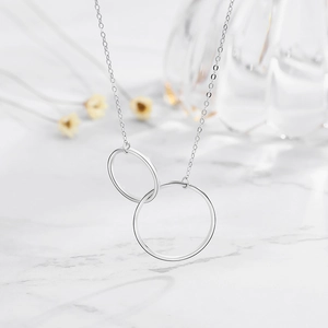Minimalist S925 sterling silver interlocking double circle necklace on white marble background