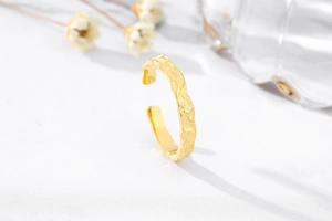 Detailed close-up of textured gold hammered finish on the irregular surface ring