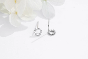 Detailed macro view of S925 sterling silver sunflower stud earrings on floral background
