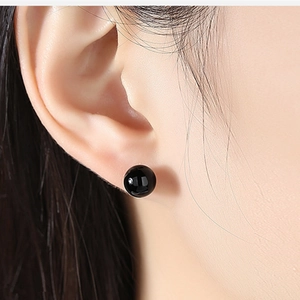 Close-up of polished black onyx stud earring in S925 sterling silver on model