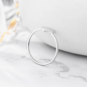 Minimalist s925 sterling silver heart ring on white pebble and marble background
