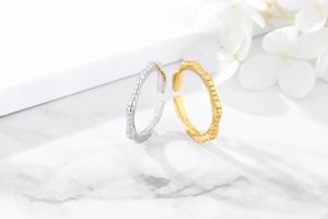 Macro detail of vertical textured S925 sterling silver adjustable rings in gold and silver