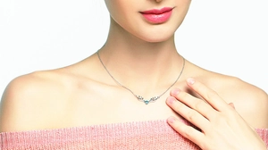 Gros plan du collier bois de renne en argent S925 avec zircon bleu porté par modèle