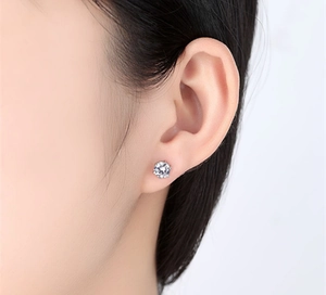 Macro view of classic six-prong s925 silver stud earring with brilliant round zirconia