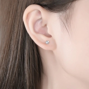 Close-up of S925 sterling silver classic six-claw stud earring worn on model ear