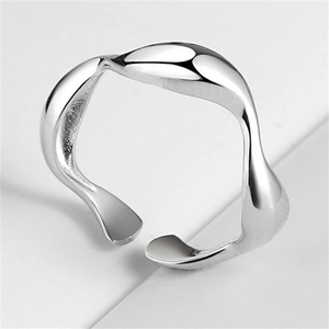 Vista macro de anillo minimalista de plata 925 con ondas fluidas y acabado pulido espejo
