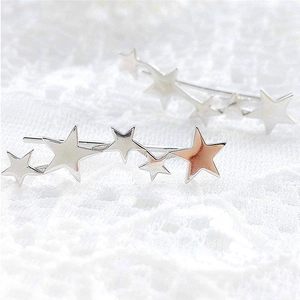 Macro shot of S925 sterling silver star crawler earrings on white lace fabric background